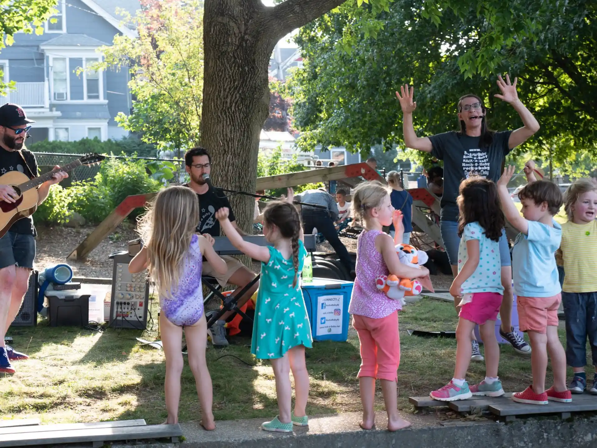 a group of people standing around a man playing guitar