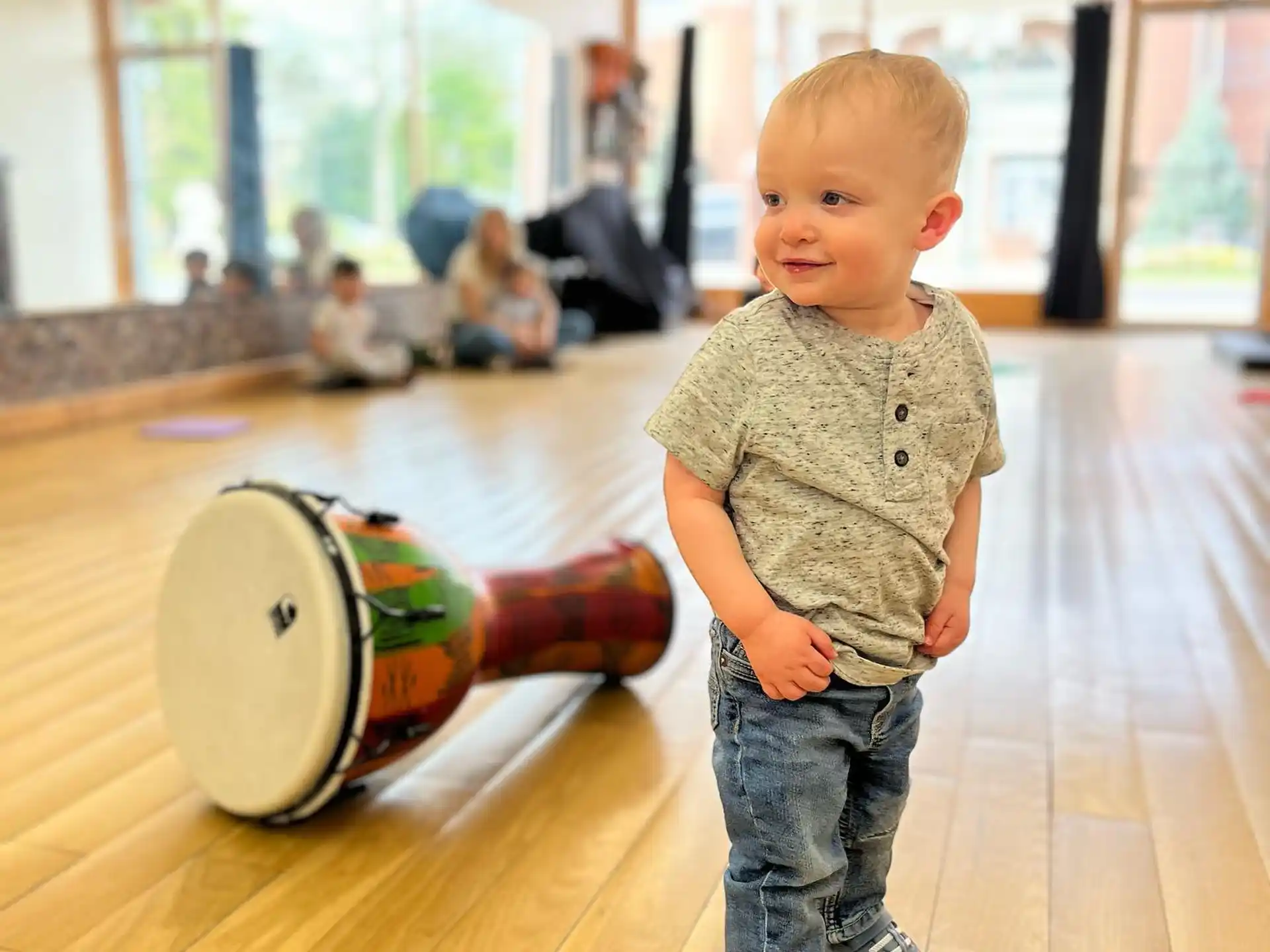 a baby standing next to a toy