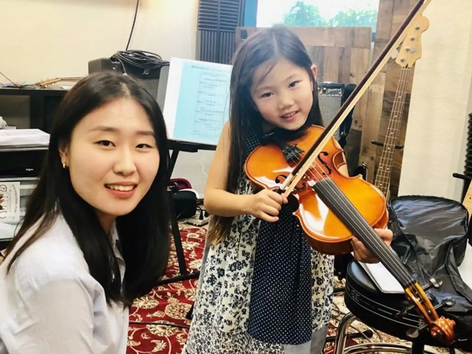 a couple of girls holding musical instruments