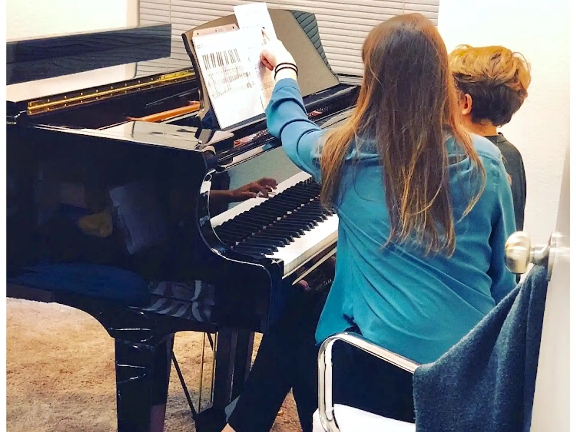 a couple of people playing piano