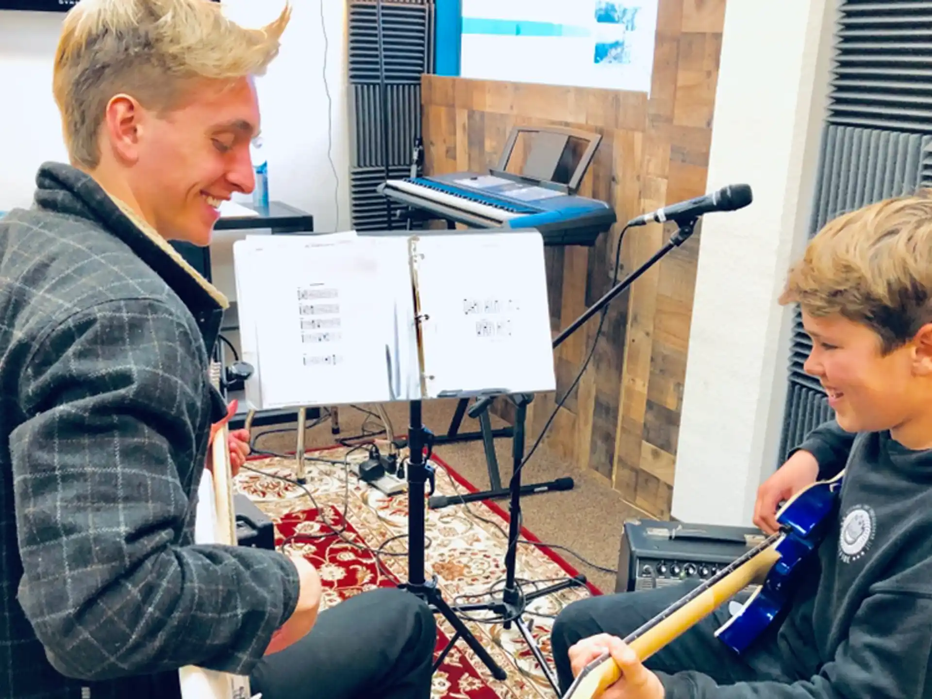 a person and a boy sitting in front of a microphone
