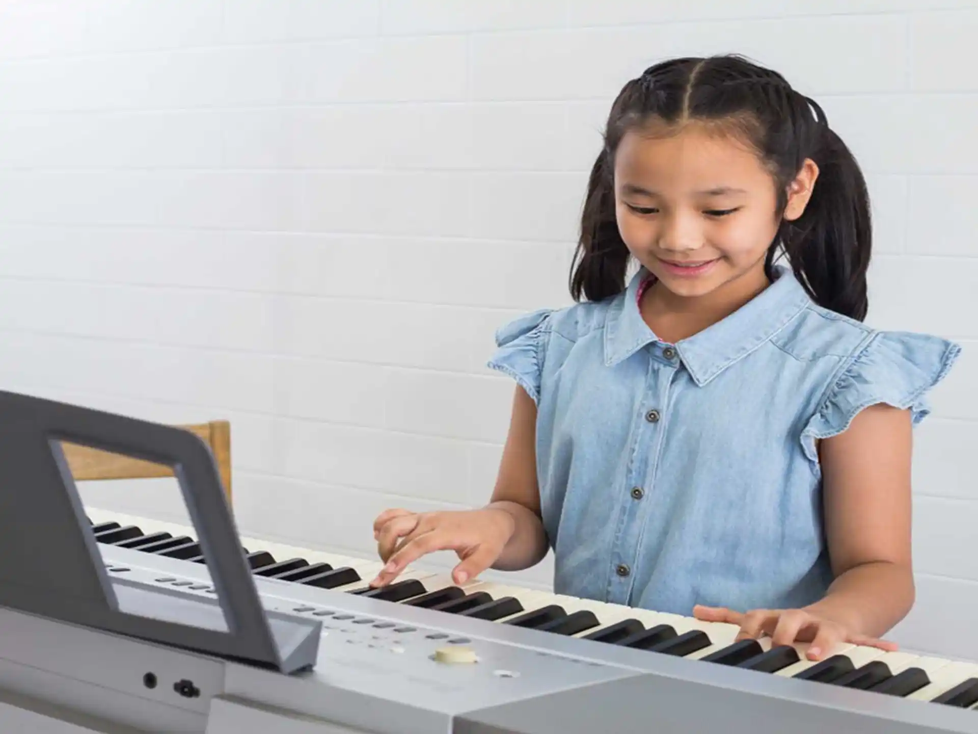 a young girl playing a piano