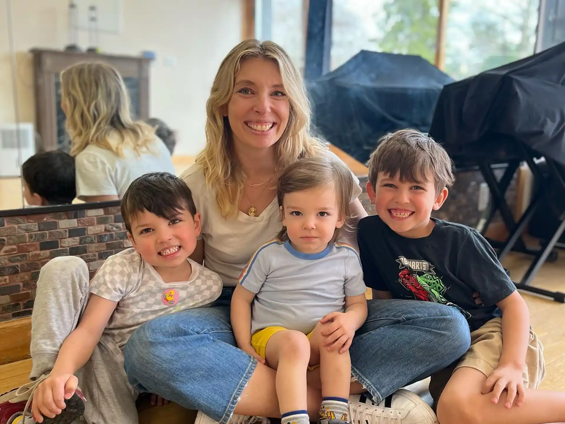a person and several children sitting on a wood floor