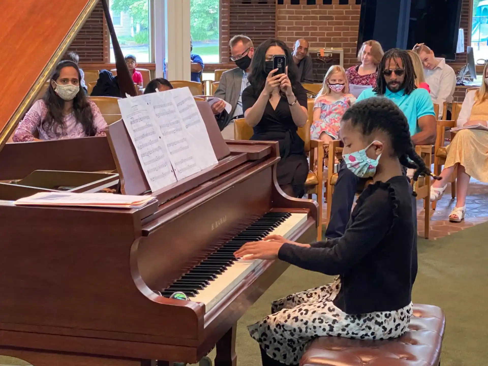 a person playing a piano in front of a group of people