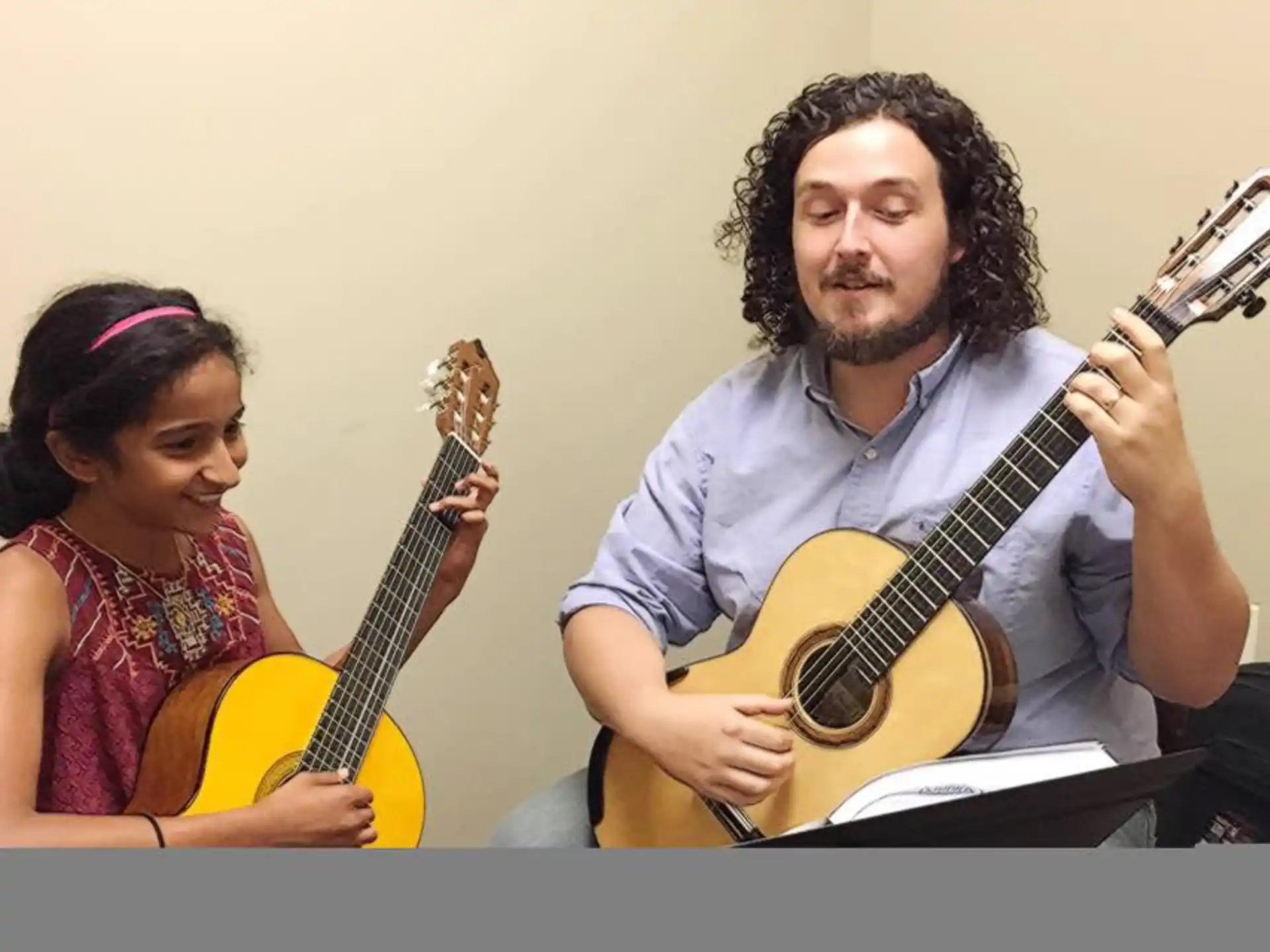 a man and a woman playing guitars