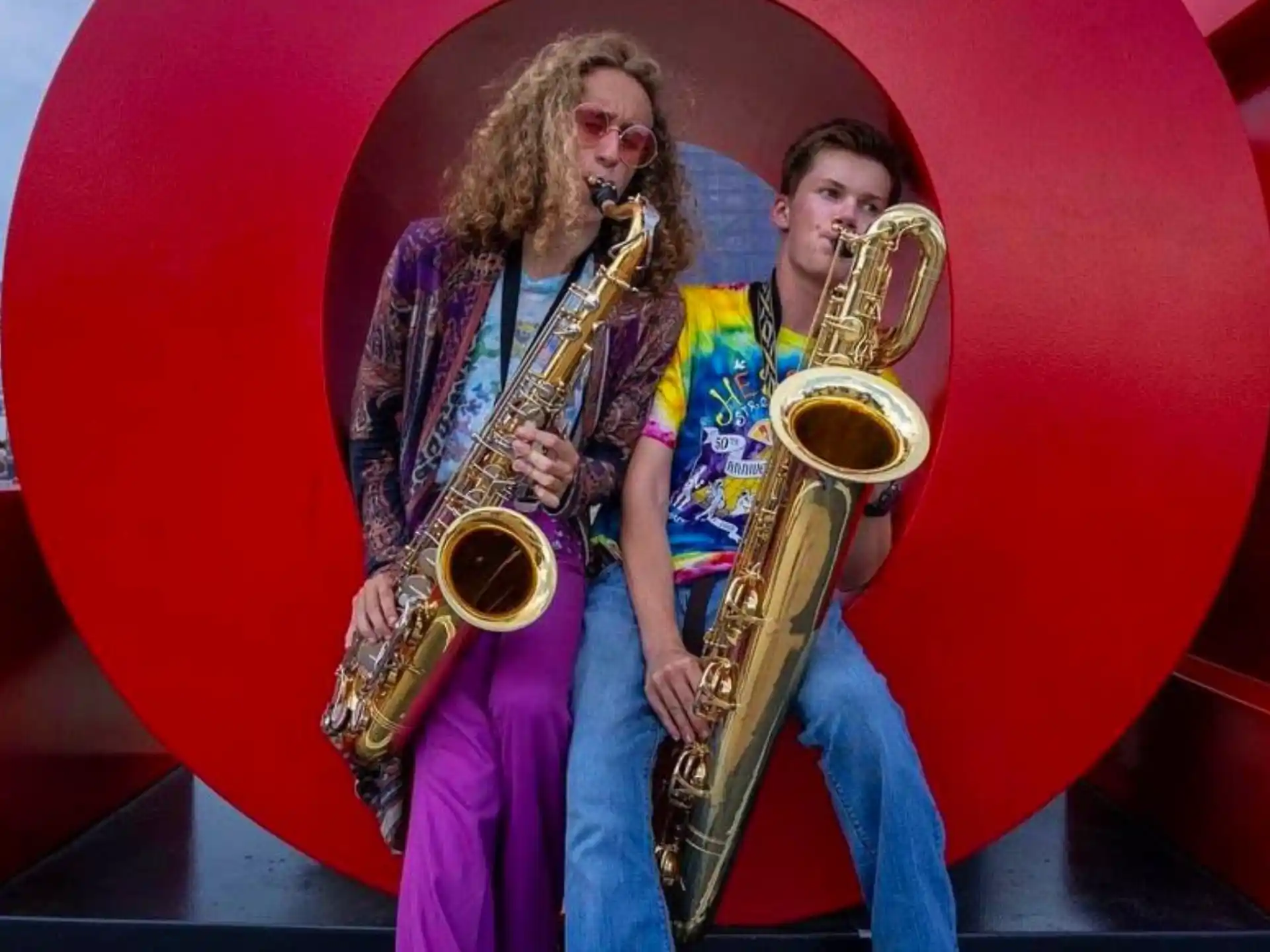 a woman playing a saxophone next to a woman playing a saxophone