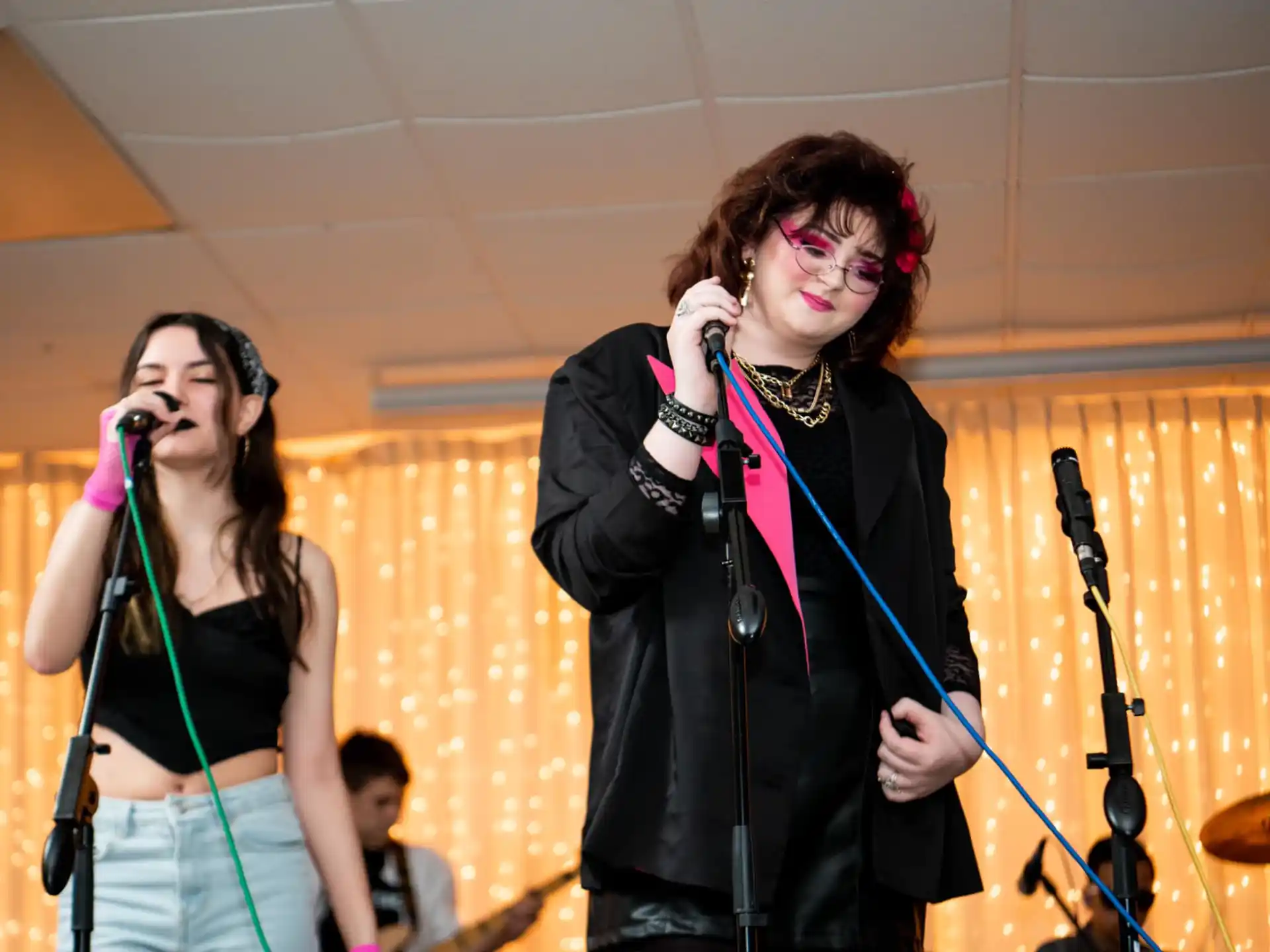 a group of people singing into microphones