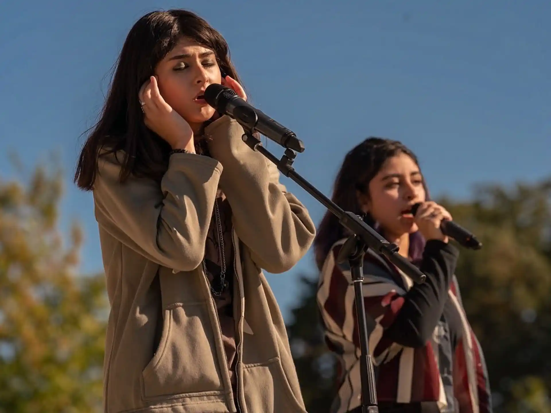 a couple of women singing into microphones