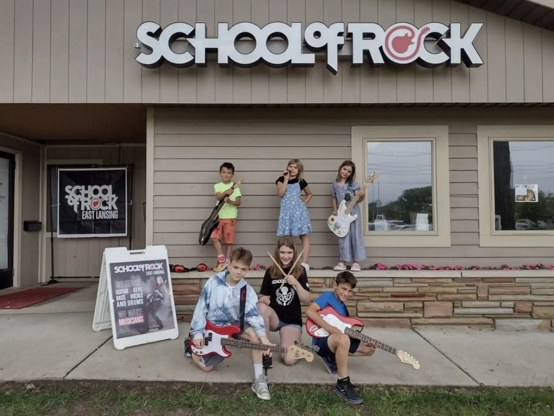 a group of people posing for a photo outside of a building