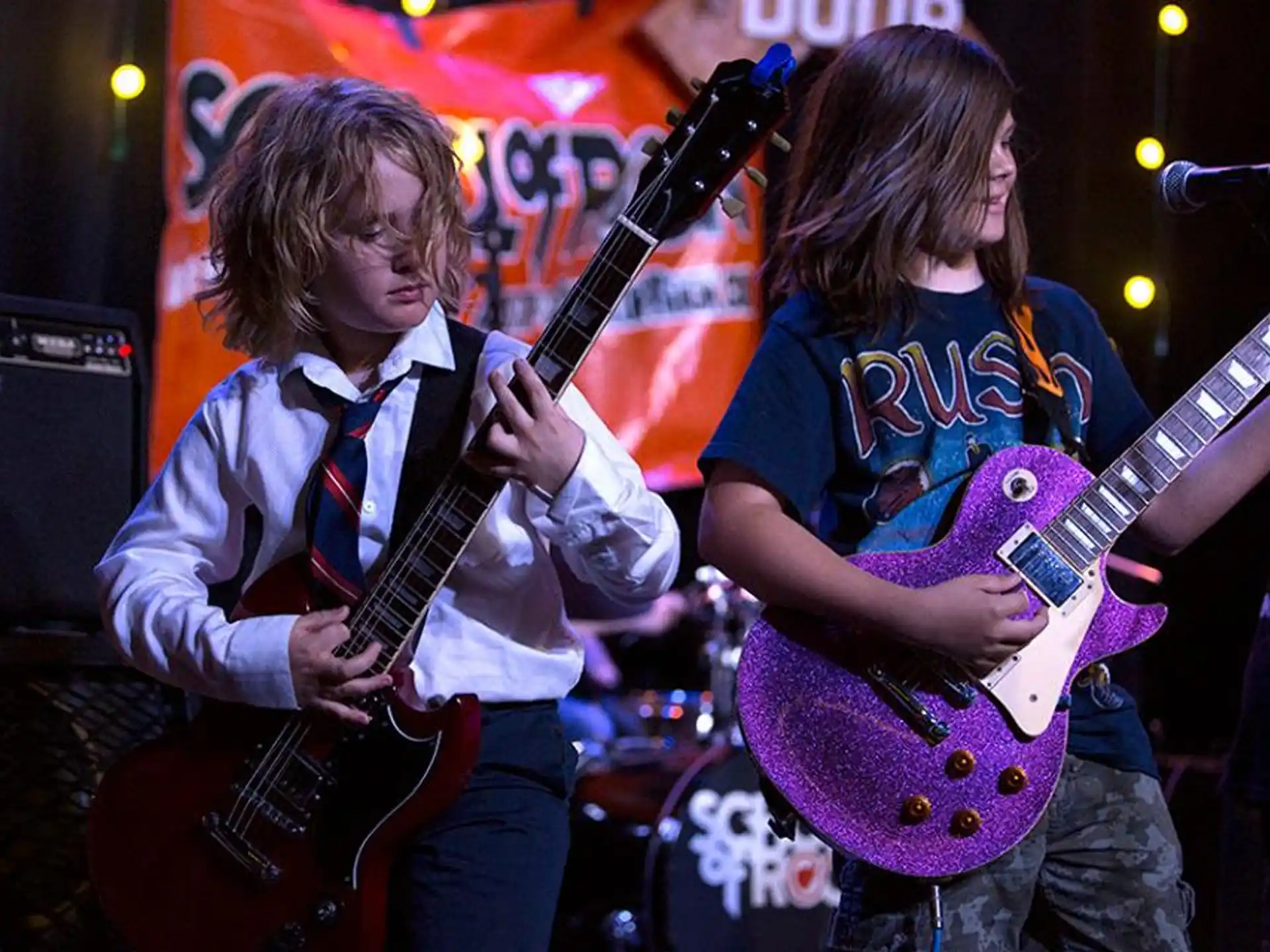 a couple of people playing guitars