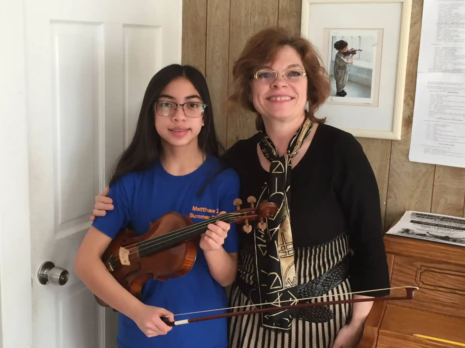 two women holding a guitar