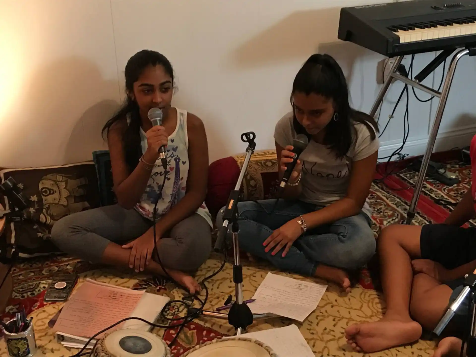 a group of people sitting on the floor with a microphone