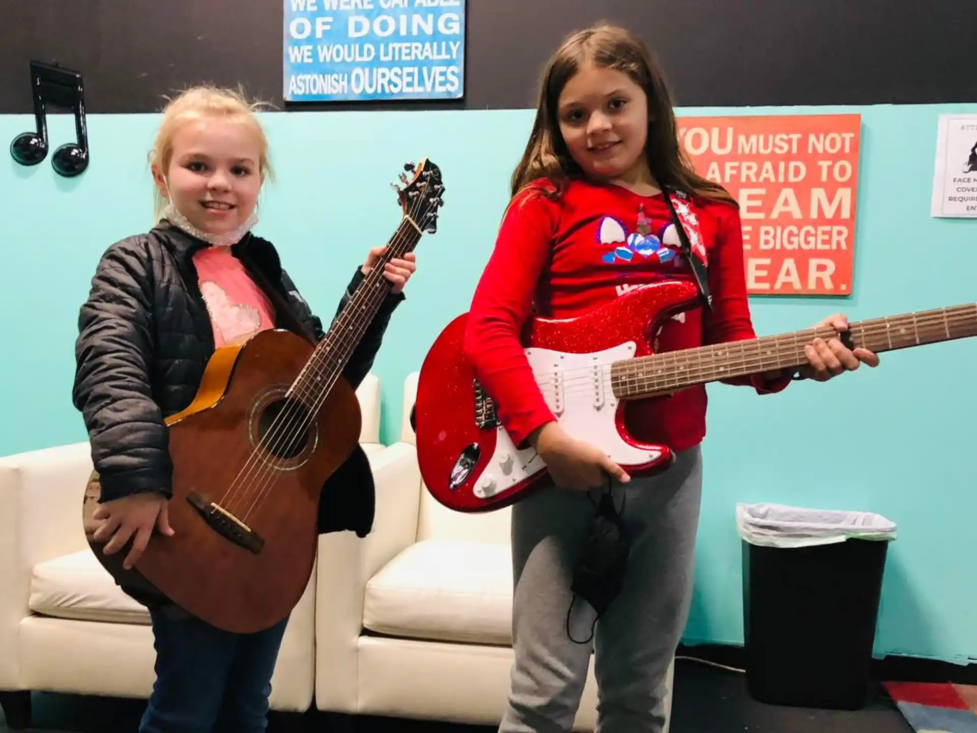 a couple of girls holding guitars