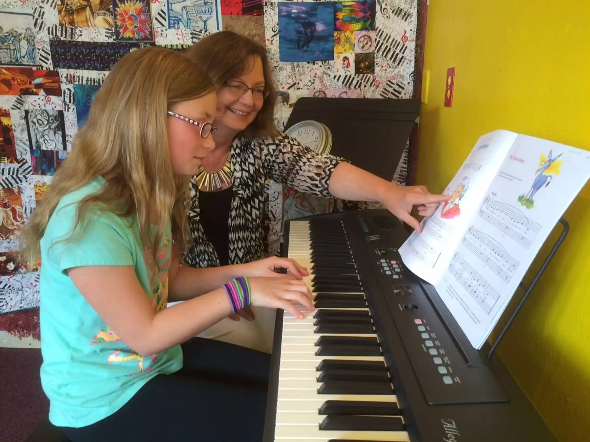a couple of girls playing a piano