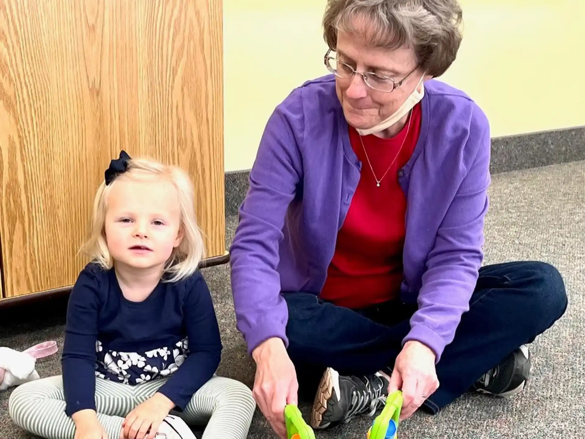 a person and a child sitting on the floor
