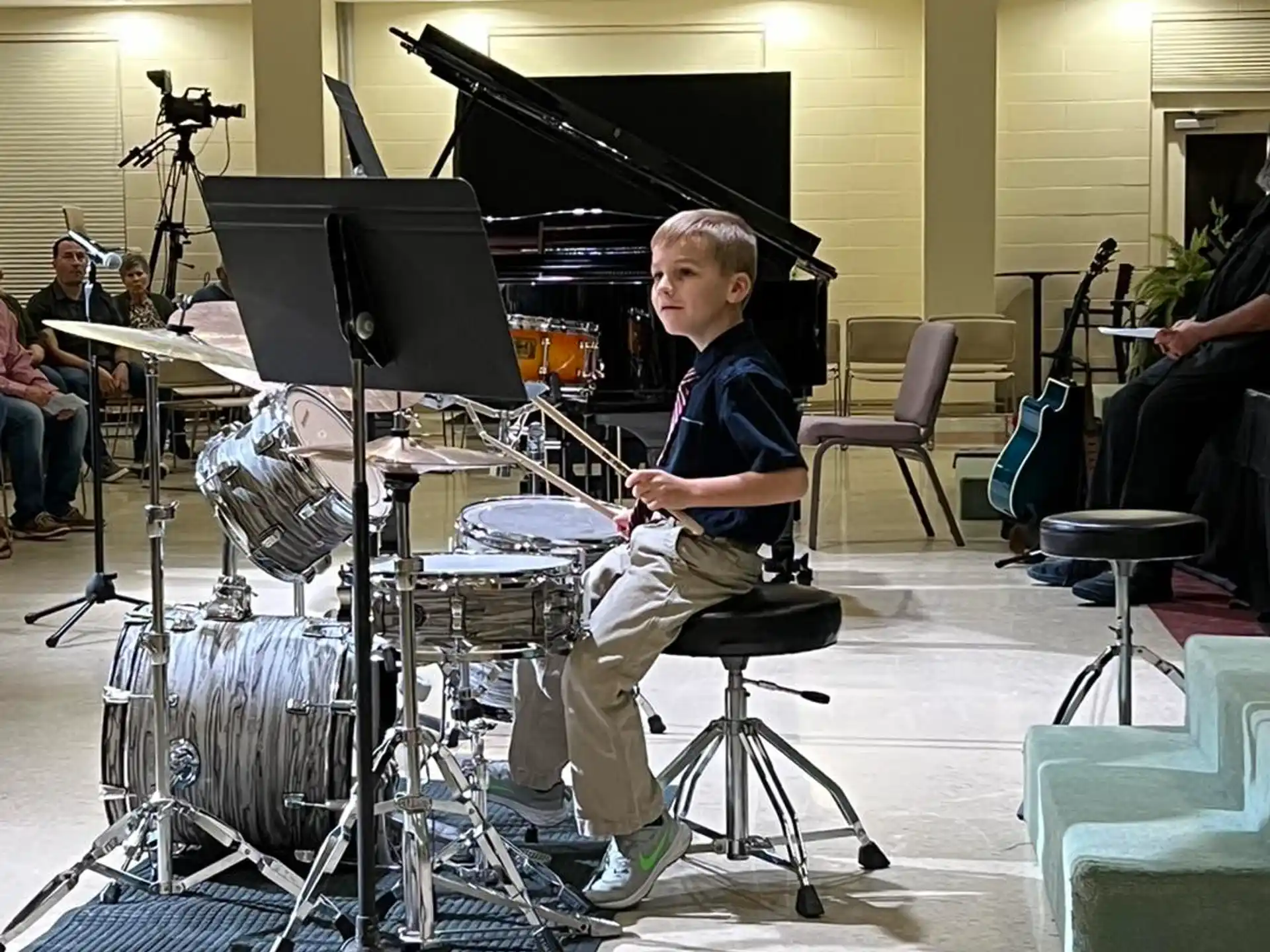 a person sitting on a stool playing the drums