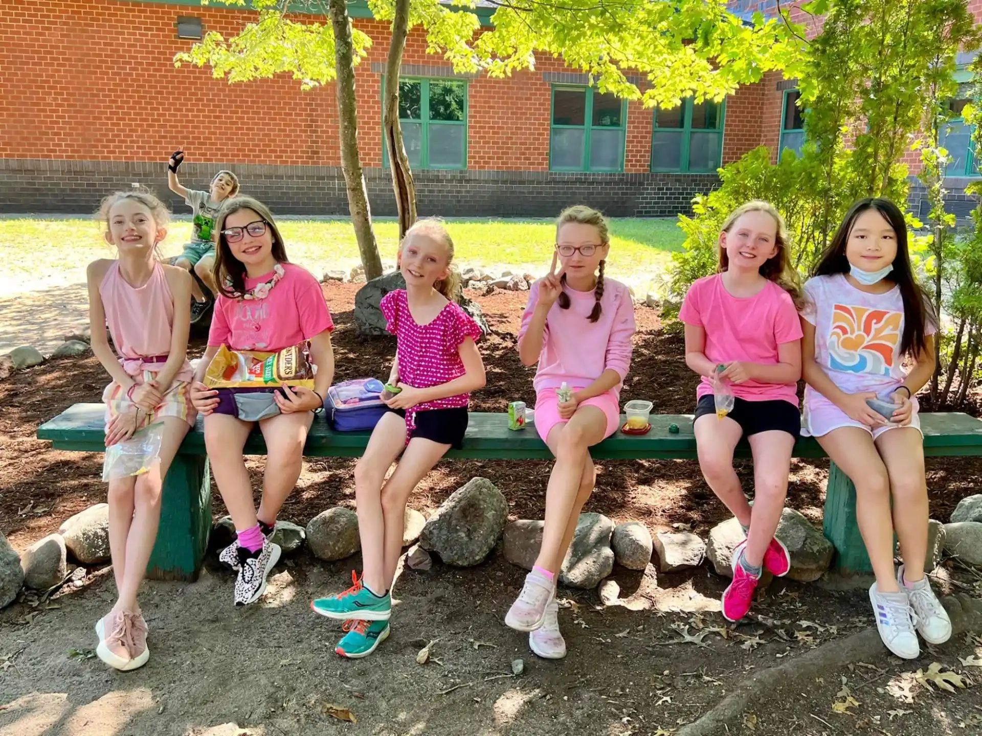 a group of girls sitting on a bench