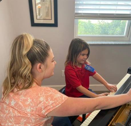 a couple of girls playing piano