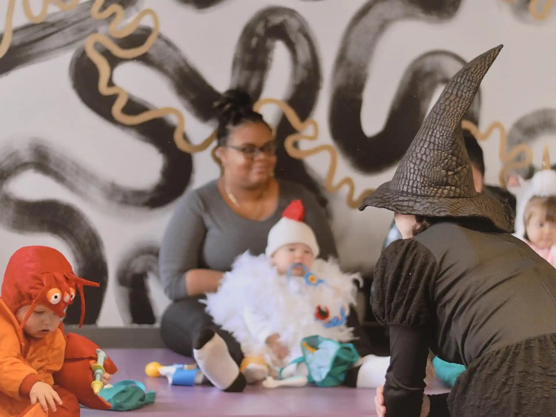 a person wearing a hat and holding a baby
