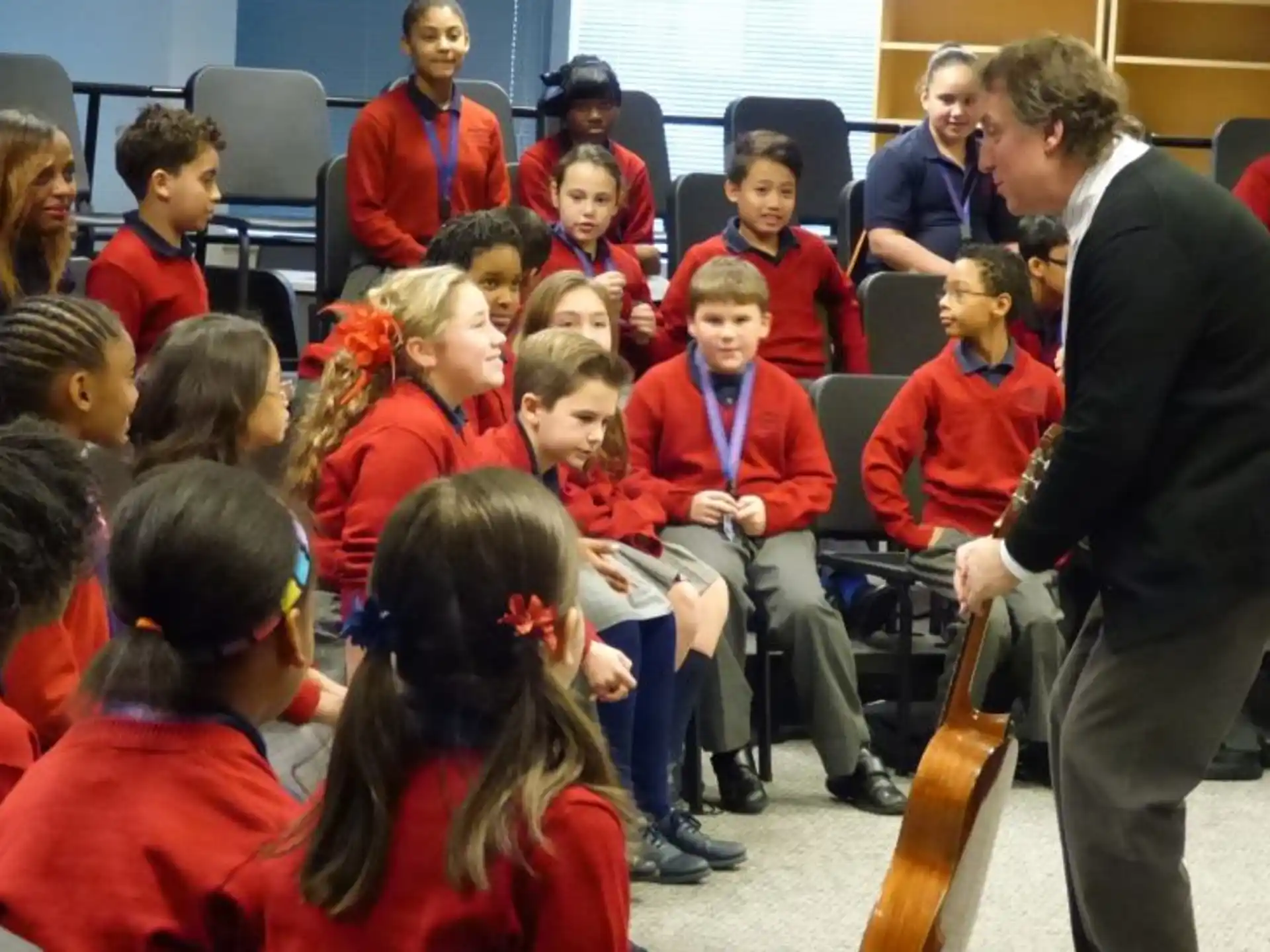 a person talking to a group of children in a room