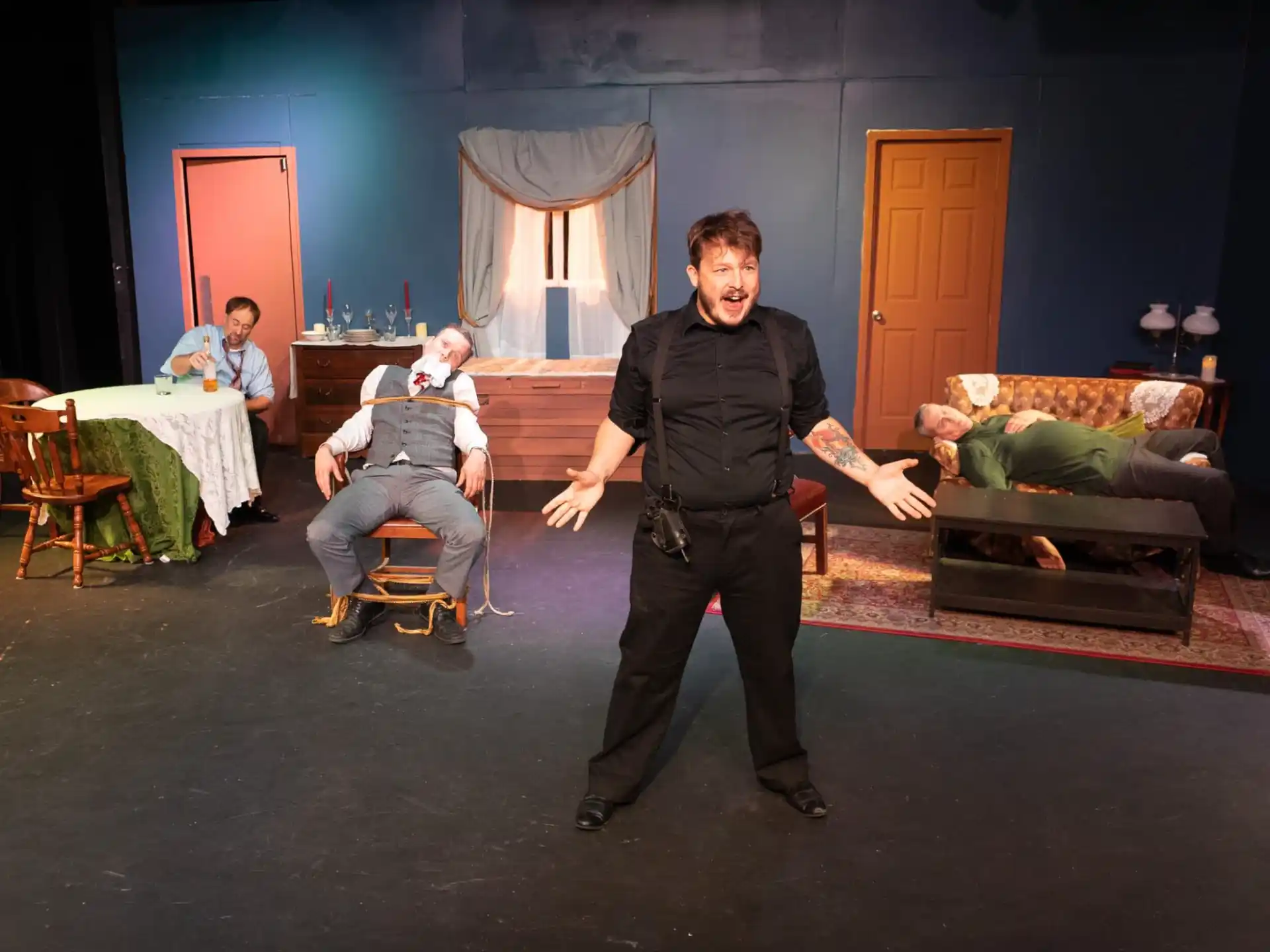 a person standing in a room with people sitting in chairs and a table