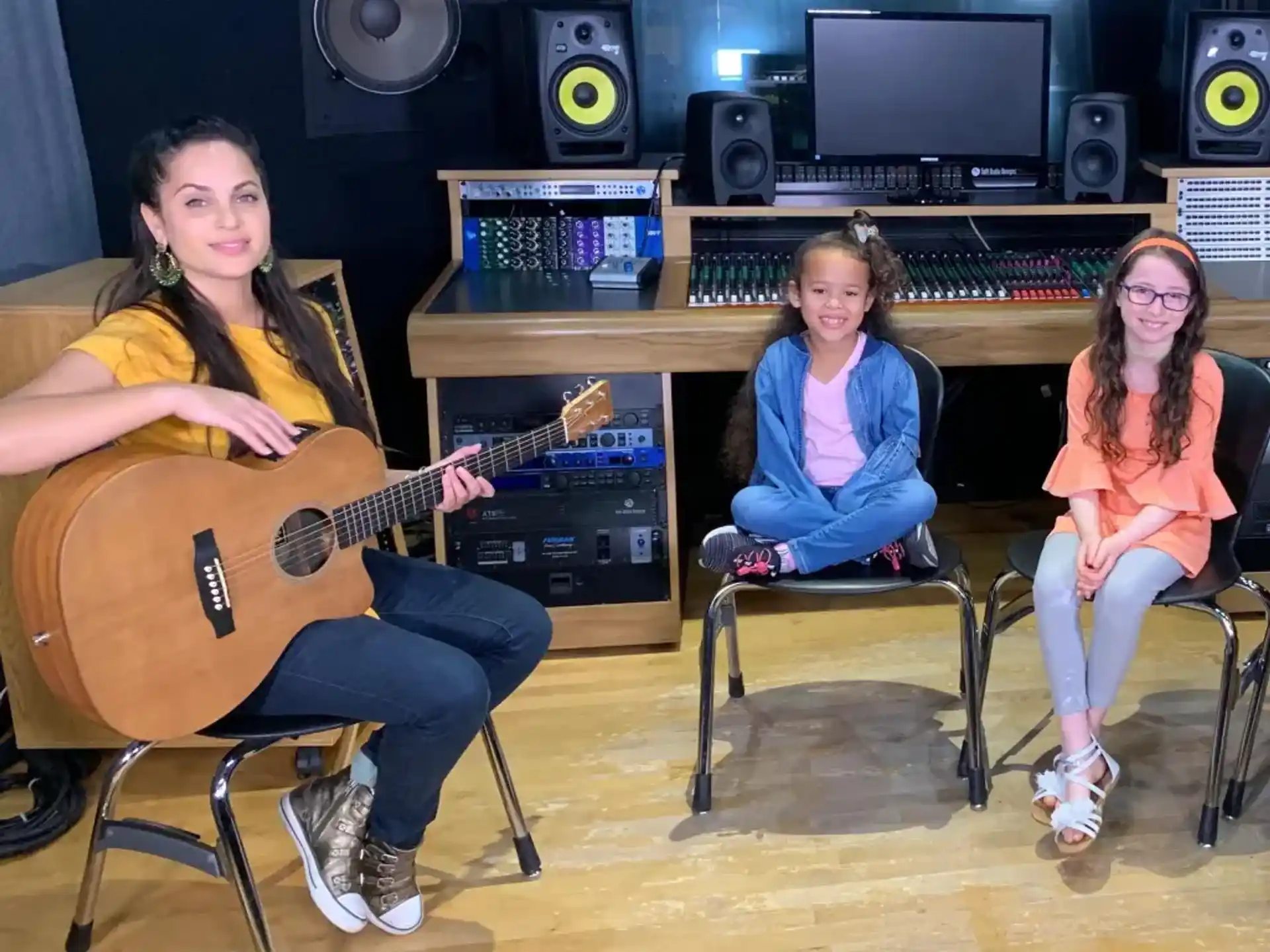 a group of people sitting in chairs with guitars in front of them