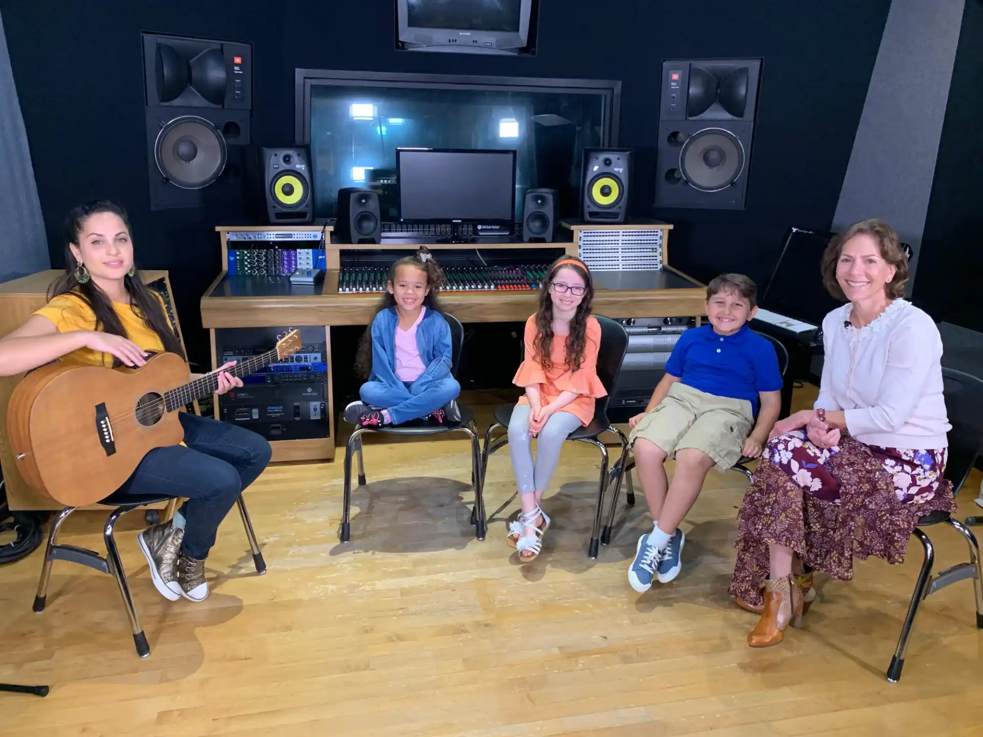 a group of people sitting in chairs with musical instruments in front of them