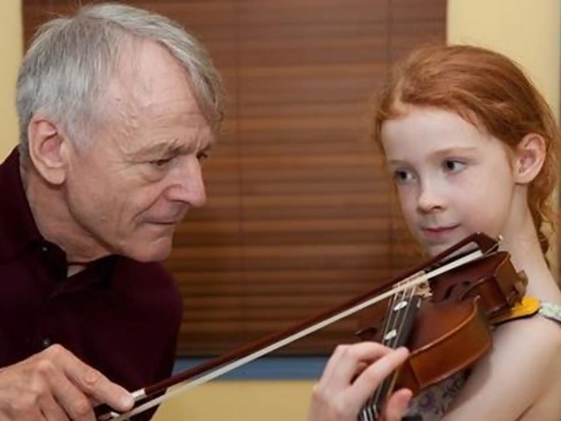 a man and a girl playing a violin