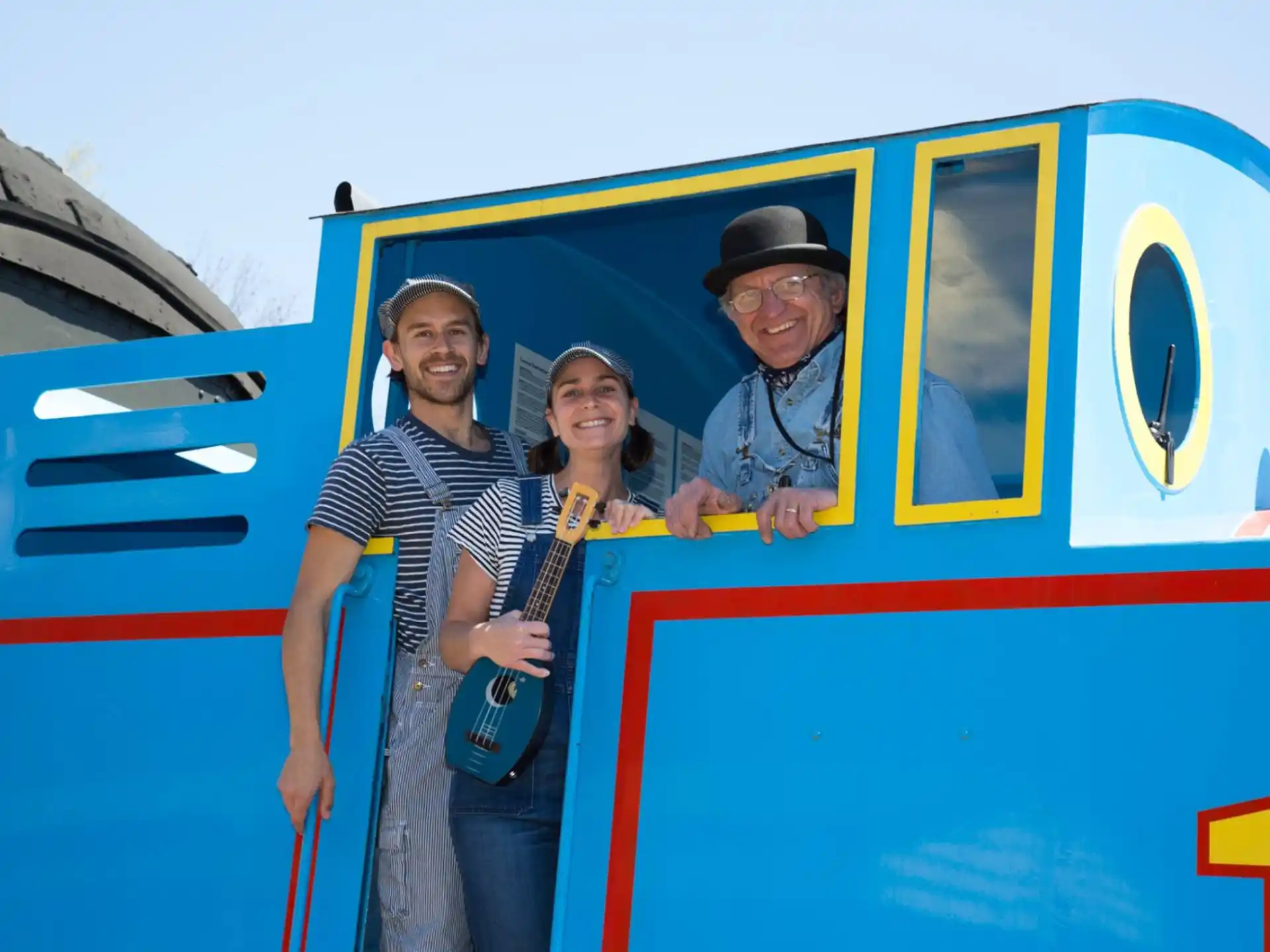 a group of people posing for a photo in front of a train