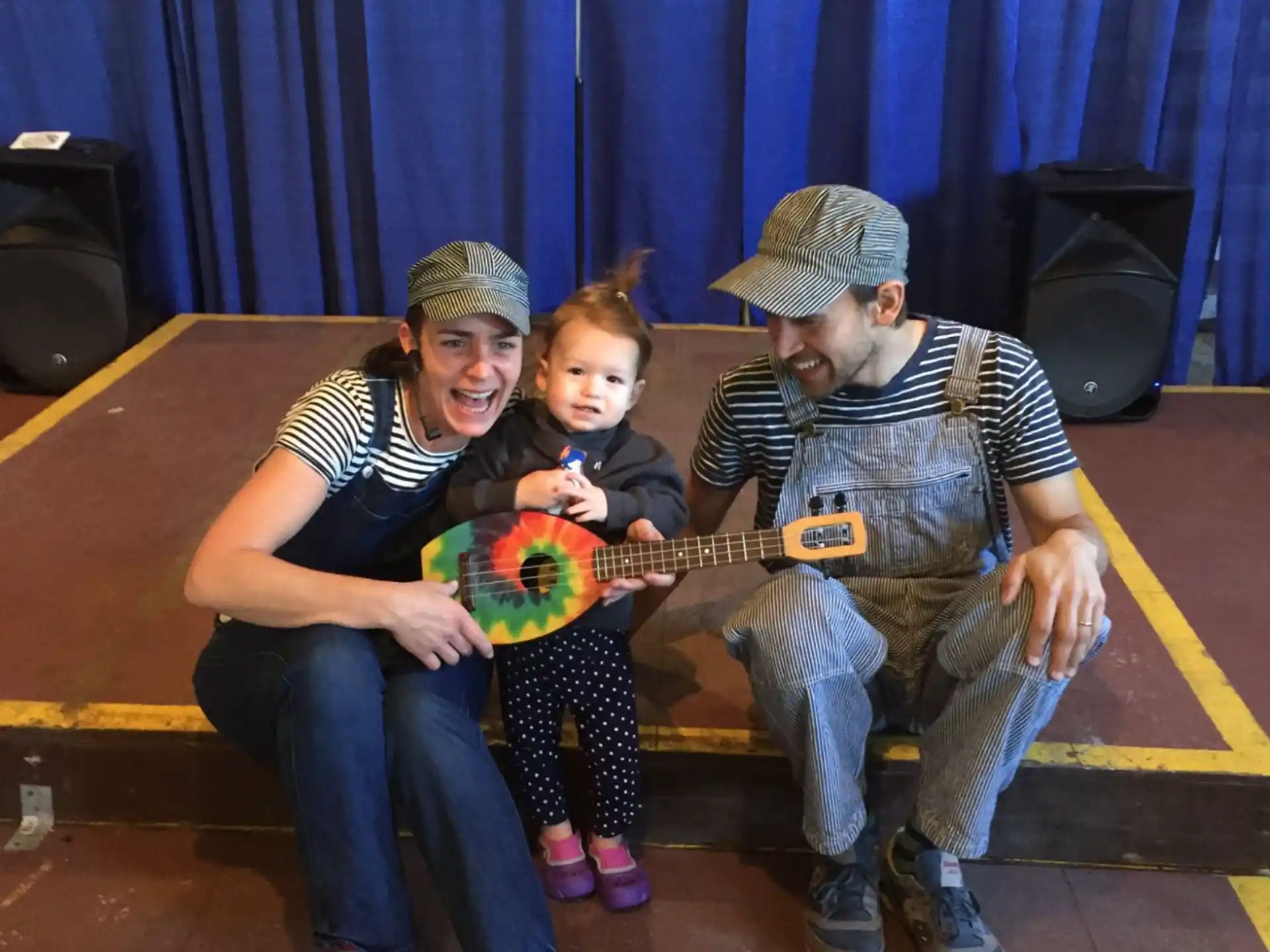 a group of people sitting on a bench holding a toy