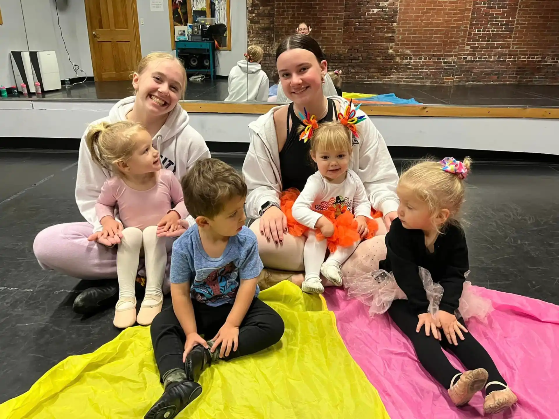 a group of people sitting on a mat posing for the camera