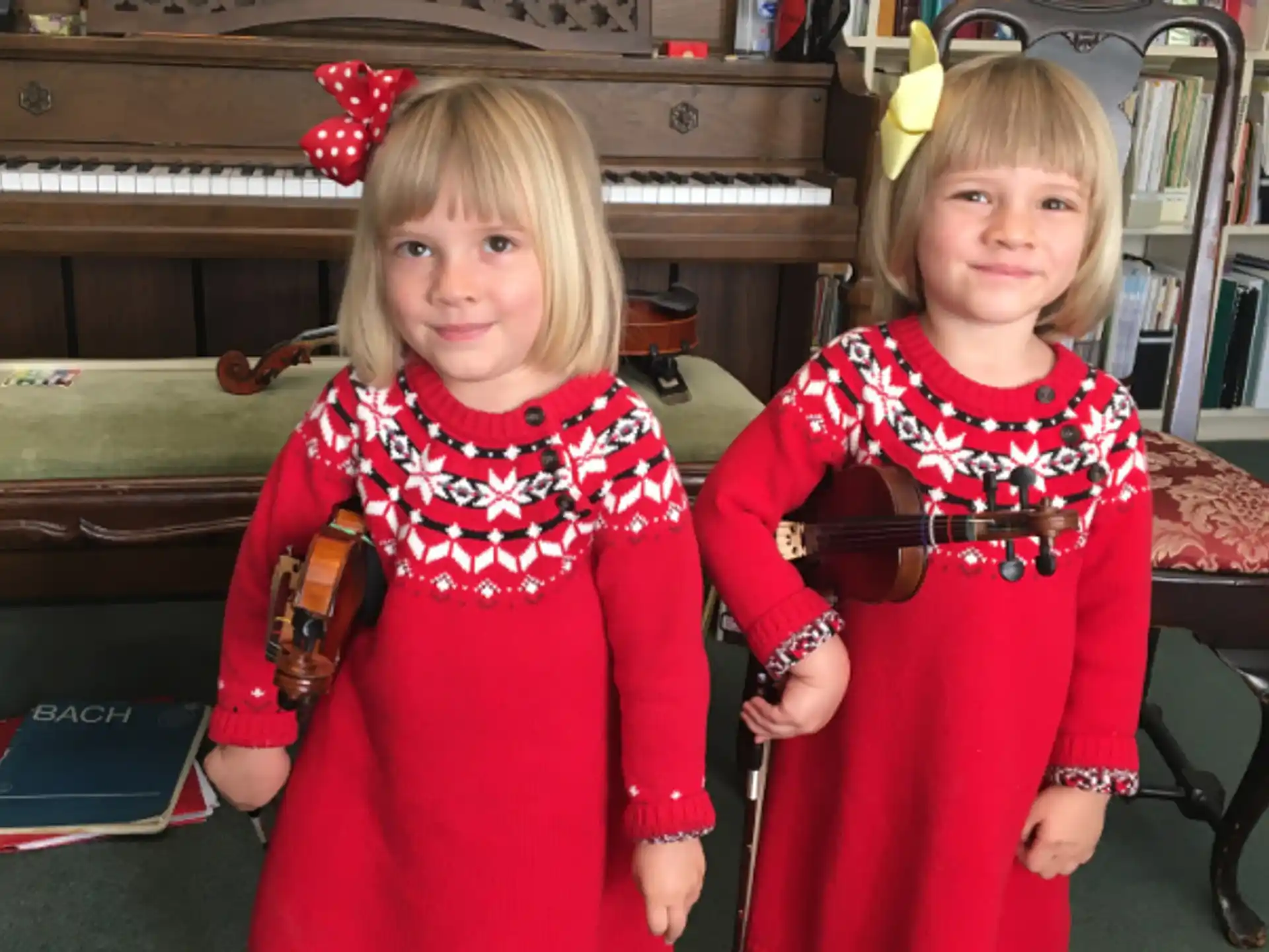 two girls wearing red dresses