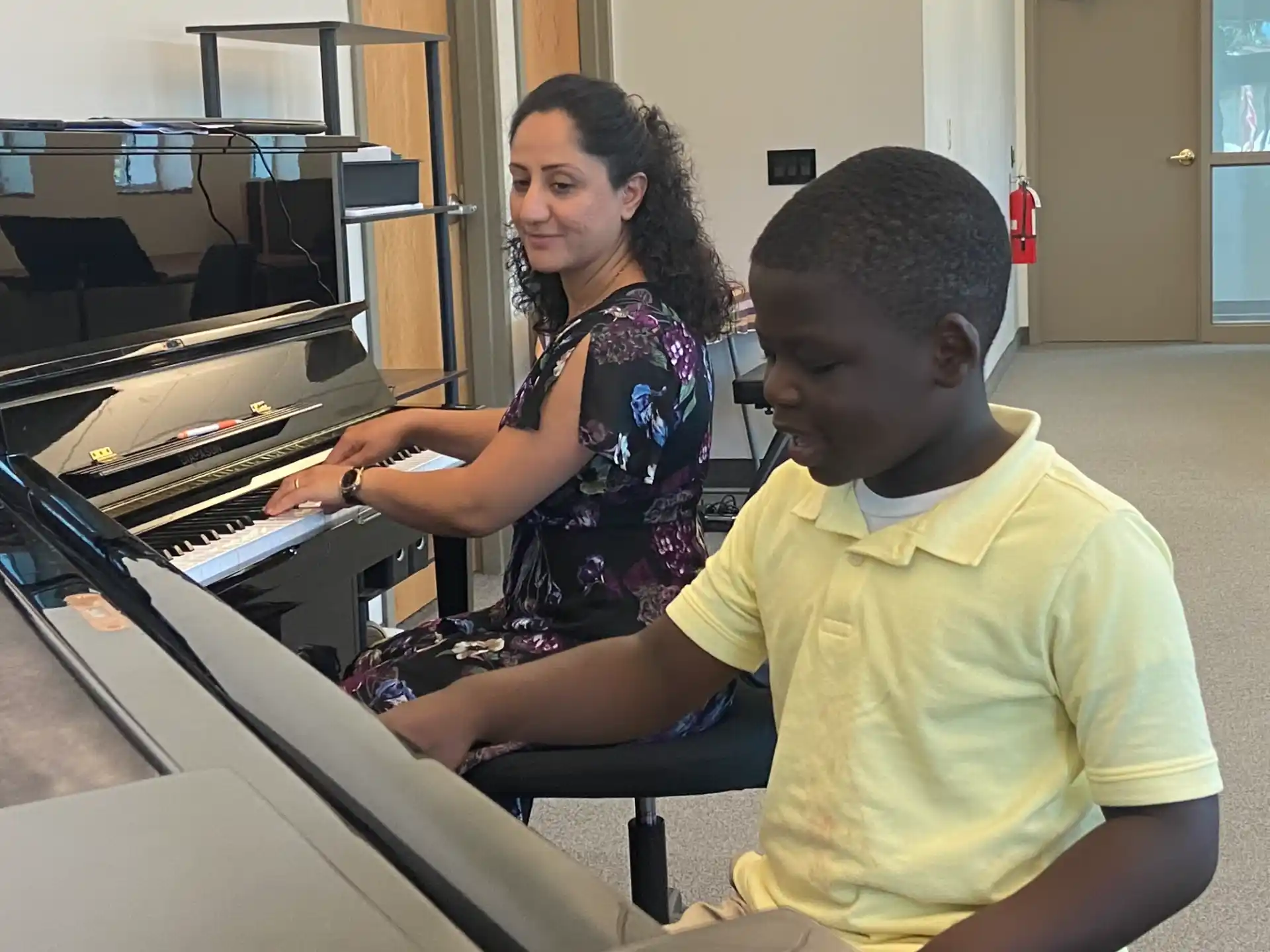 a man and a boy playing piano