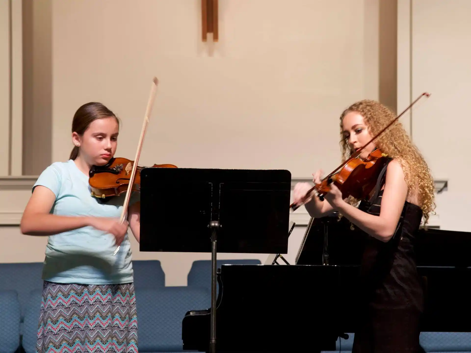 a person playing a violin next to a person playing a violin