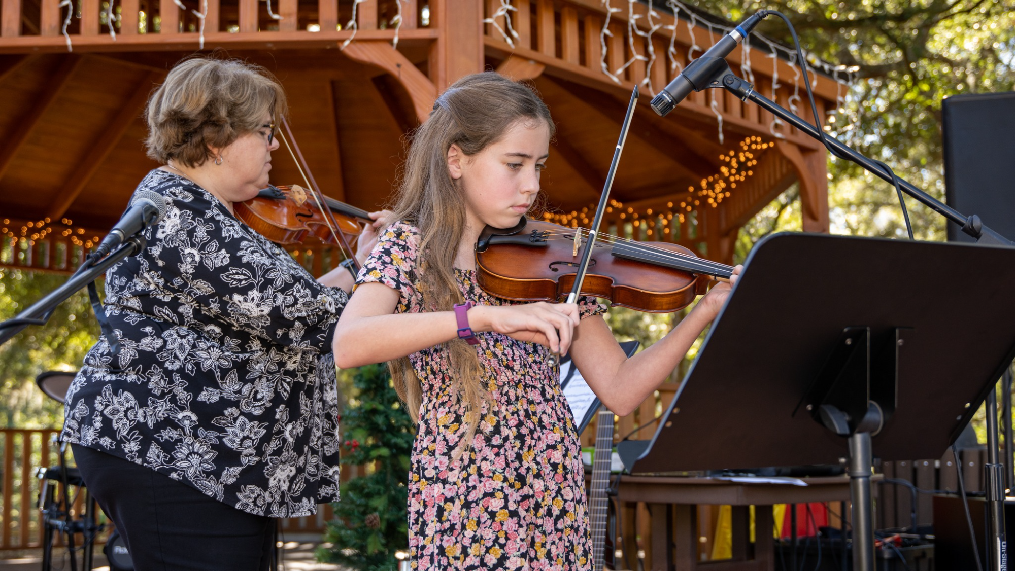 a woman playing a violin next to a woman playing a piano