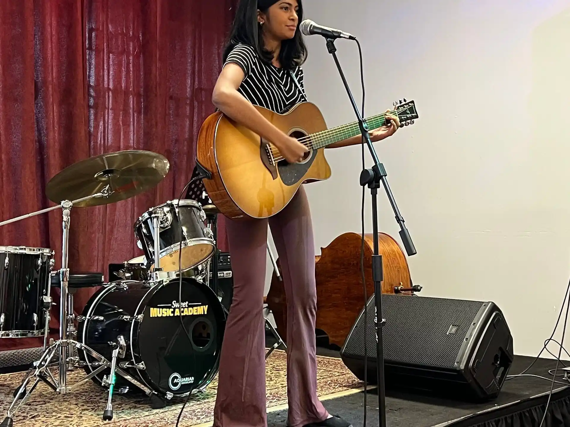 a woman playing a guitar on a stage