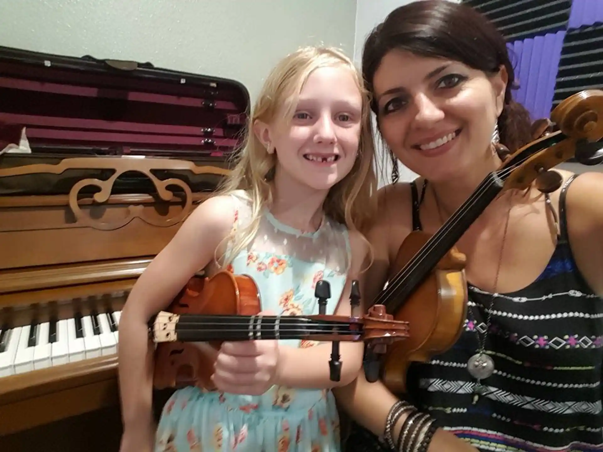 a woman and a girl playing the violin