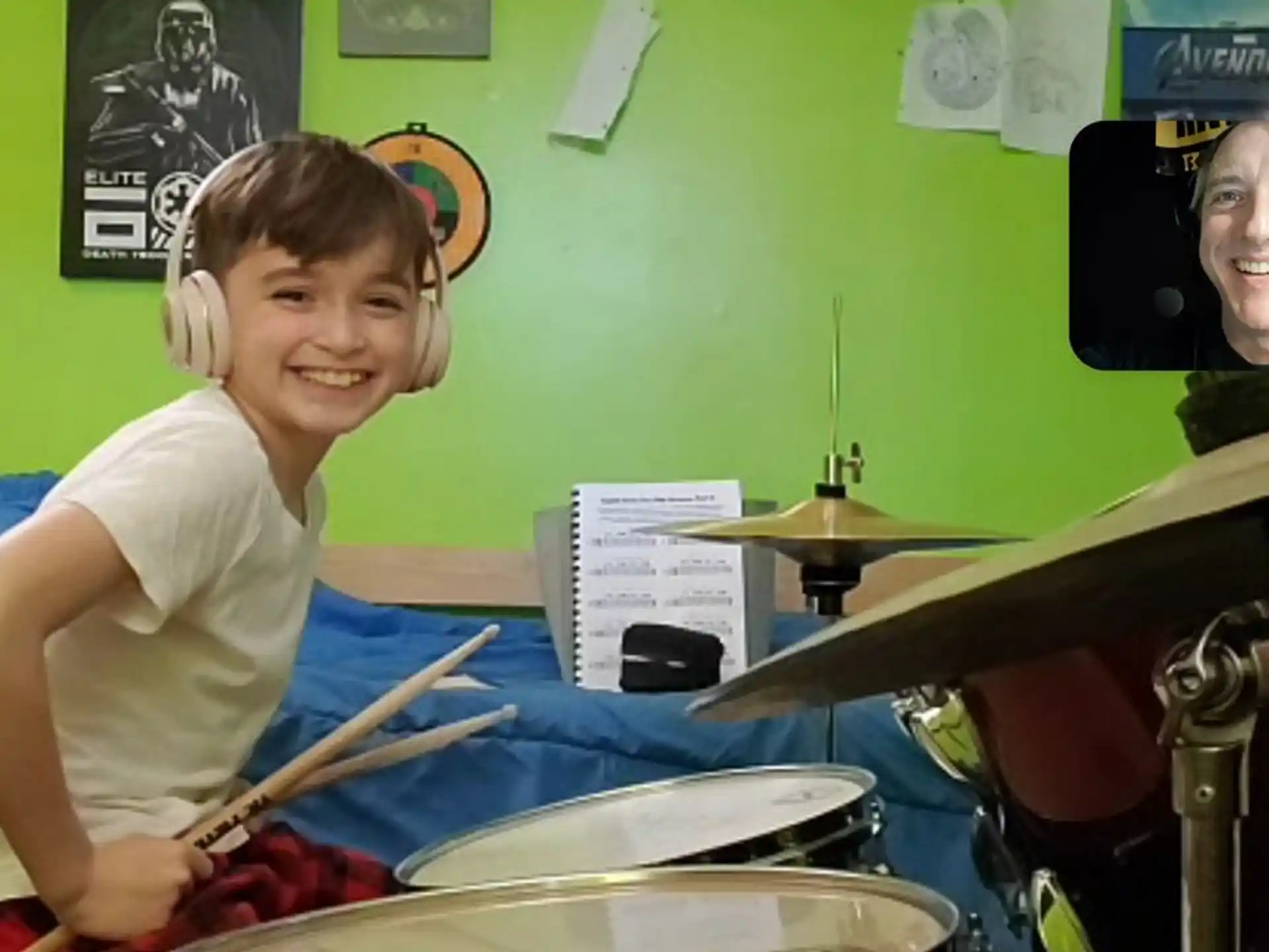 a boy wearing headphones and playing drums
