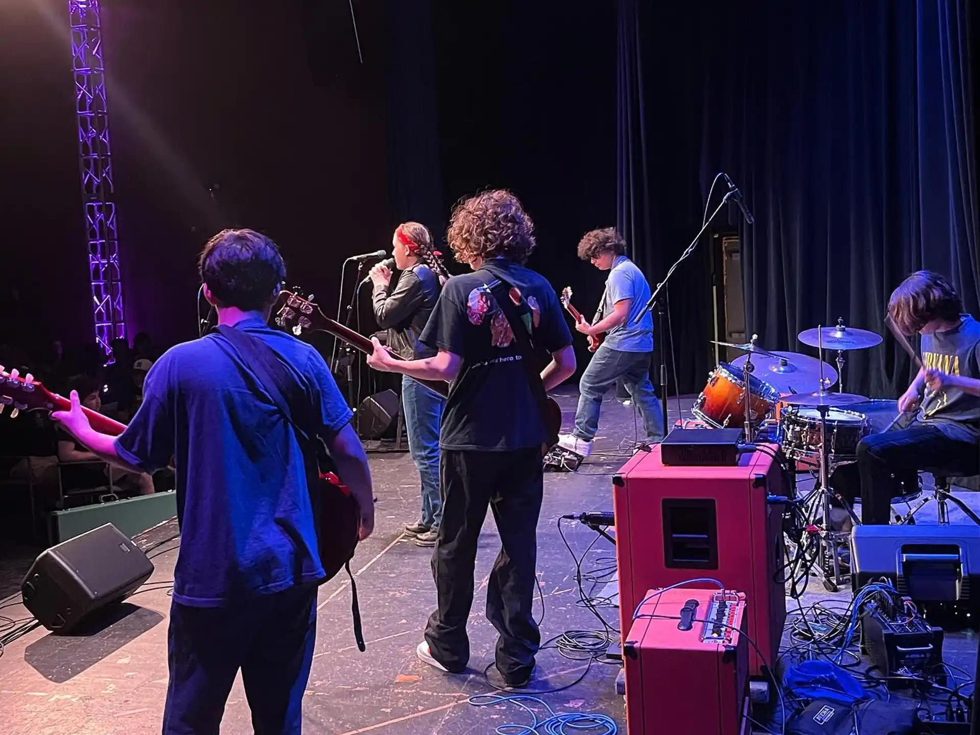 a group of people playing instruments on a stage