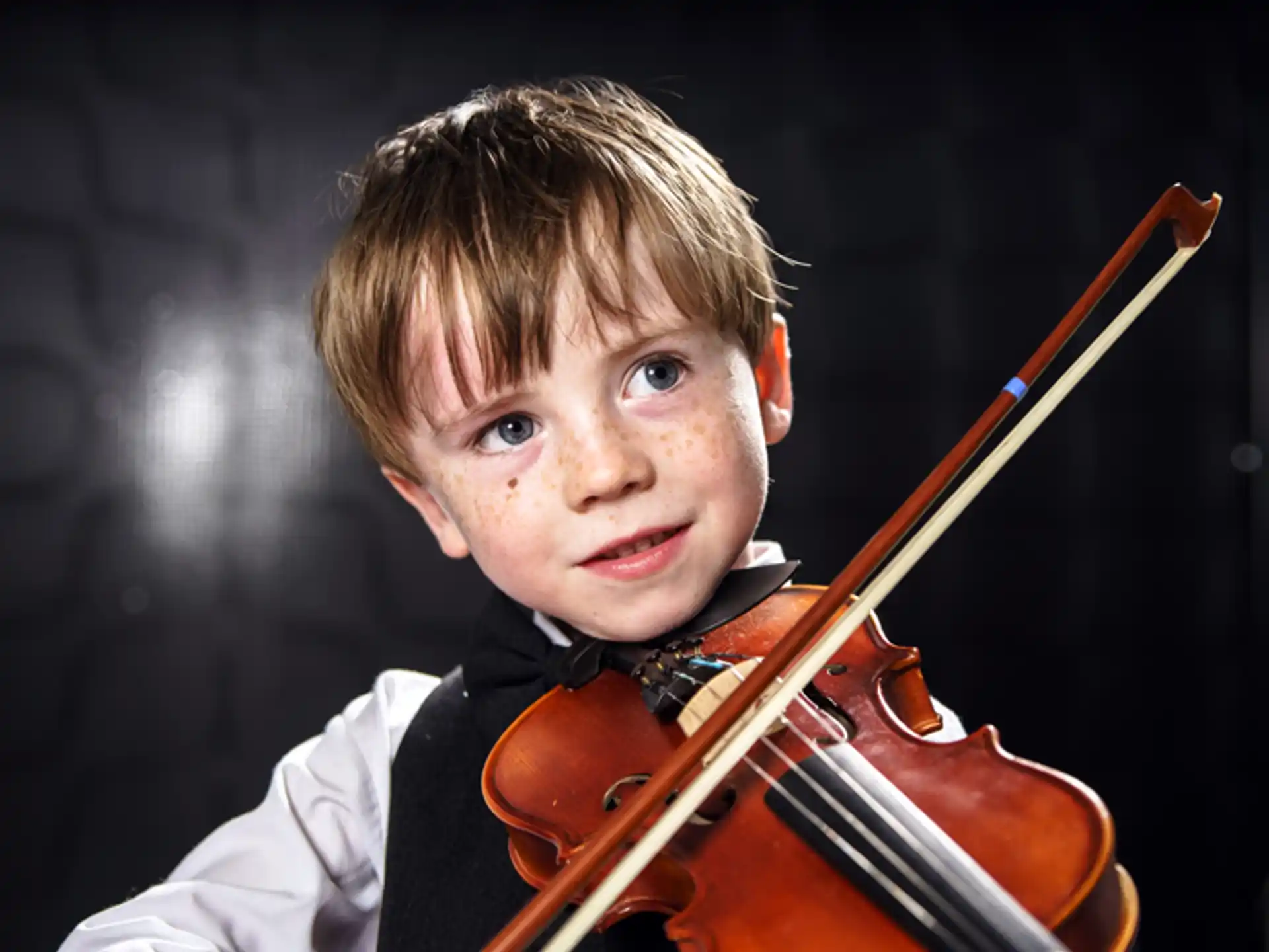 a boy holding a violin