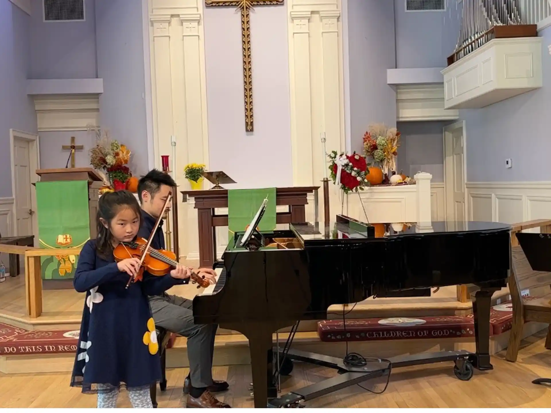 a person and a girl playing the piano