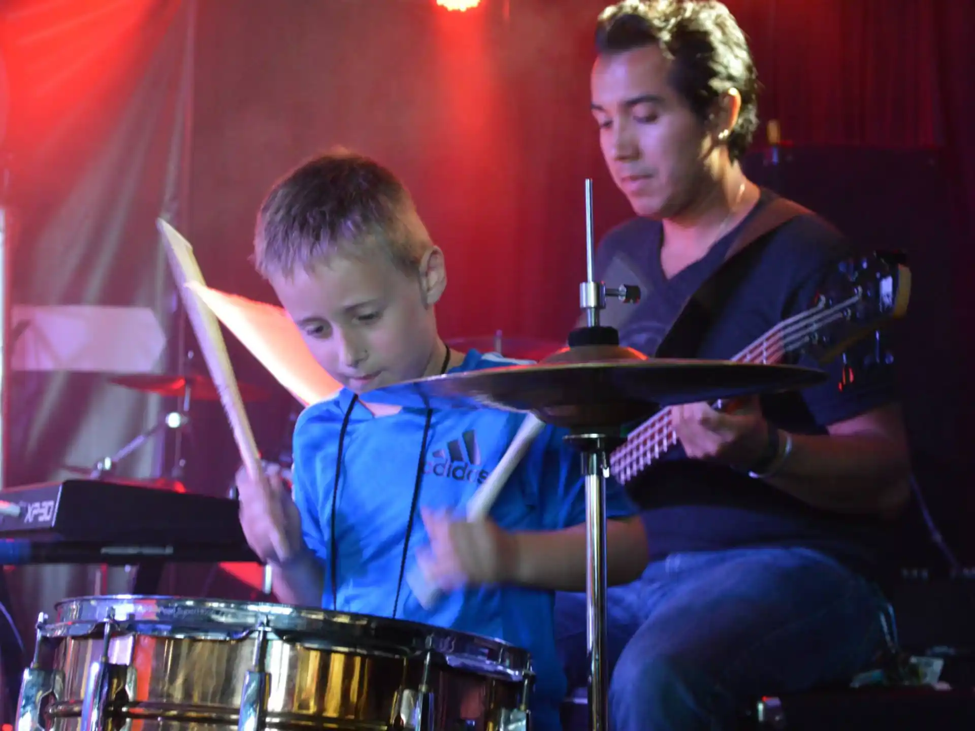 a person and a boy playing instruments