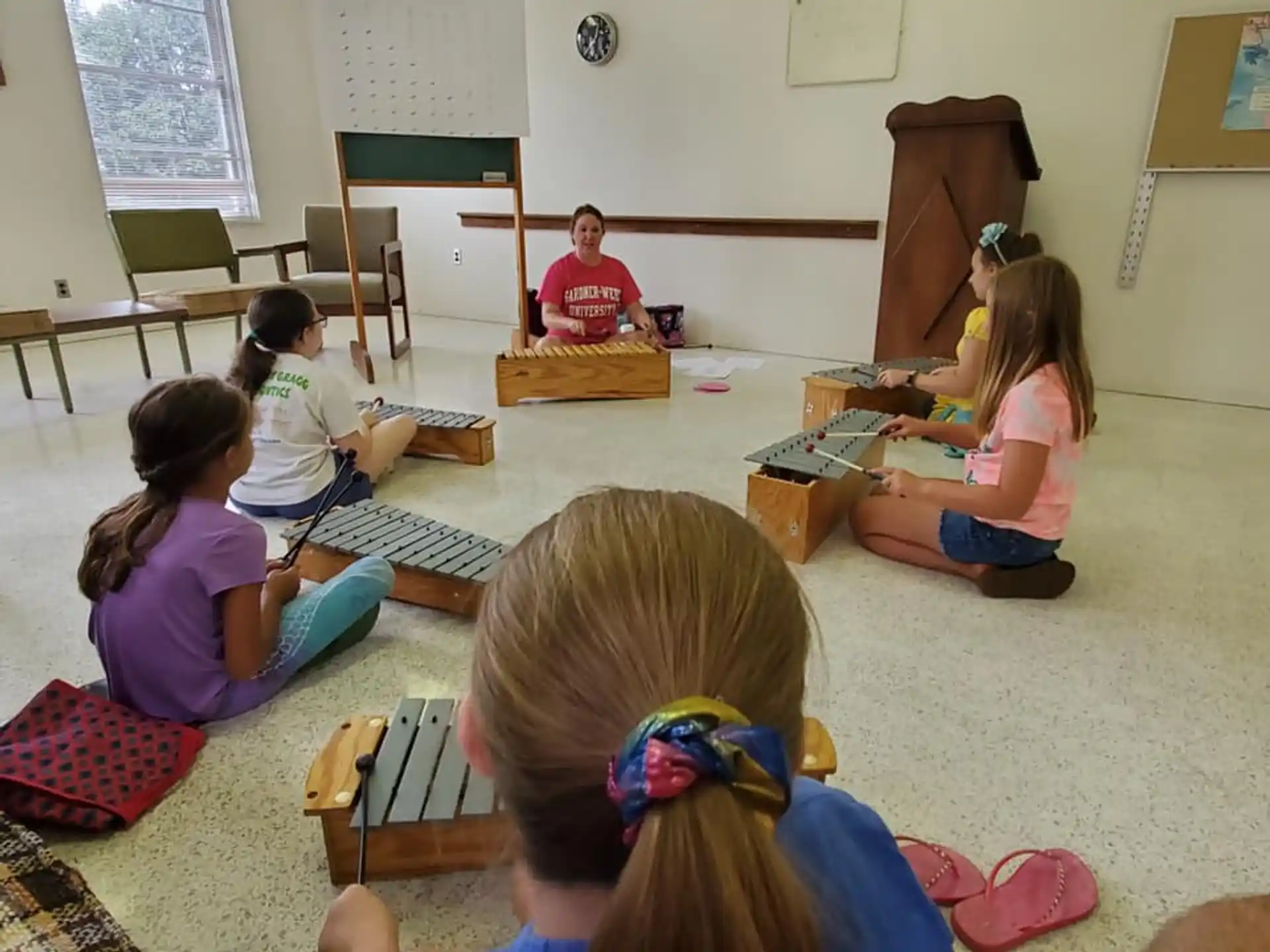 a group of children sitting on the floor playing a game
