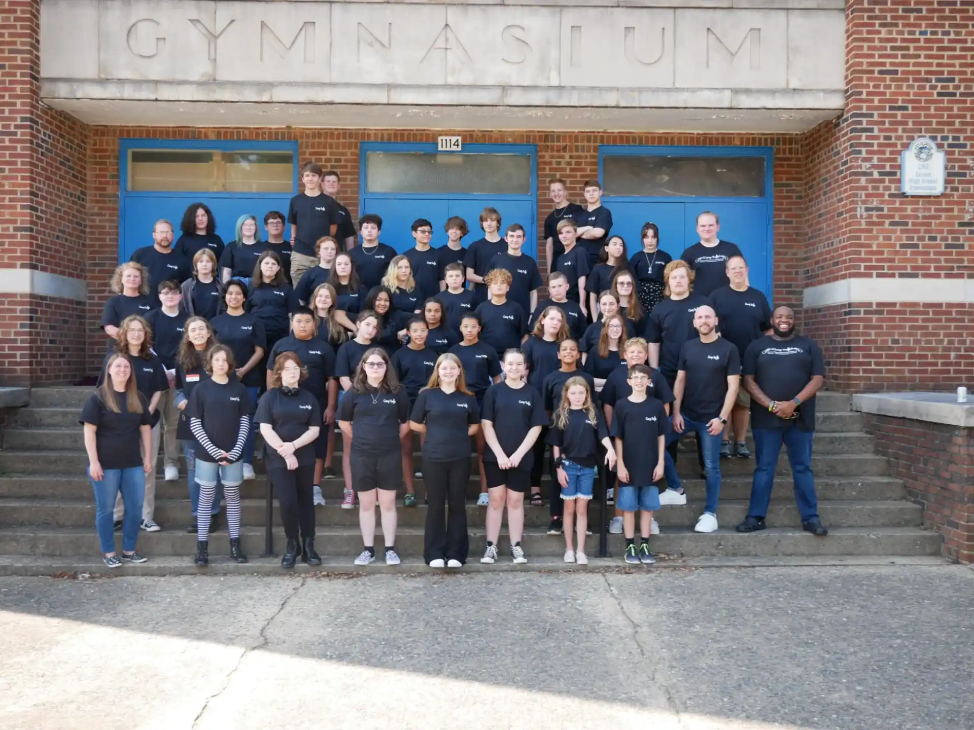 a group of people posing for a photo in front of a building