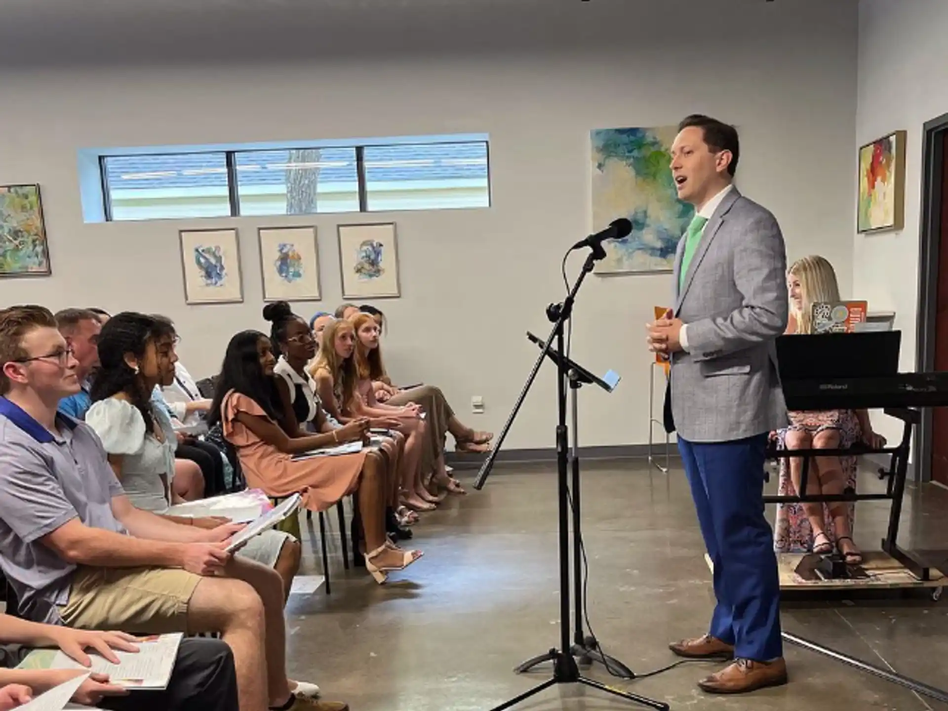 a person speaking to a group of people in a room