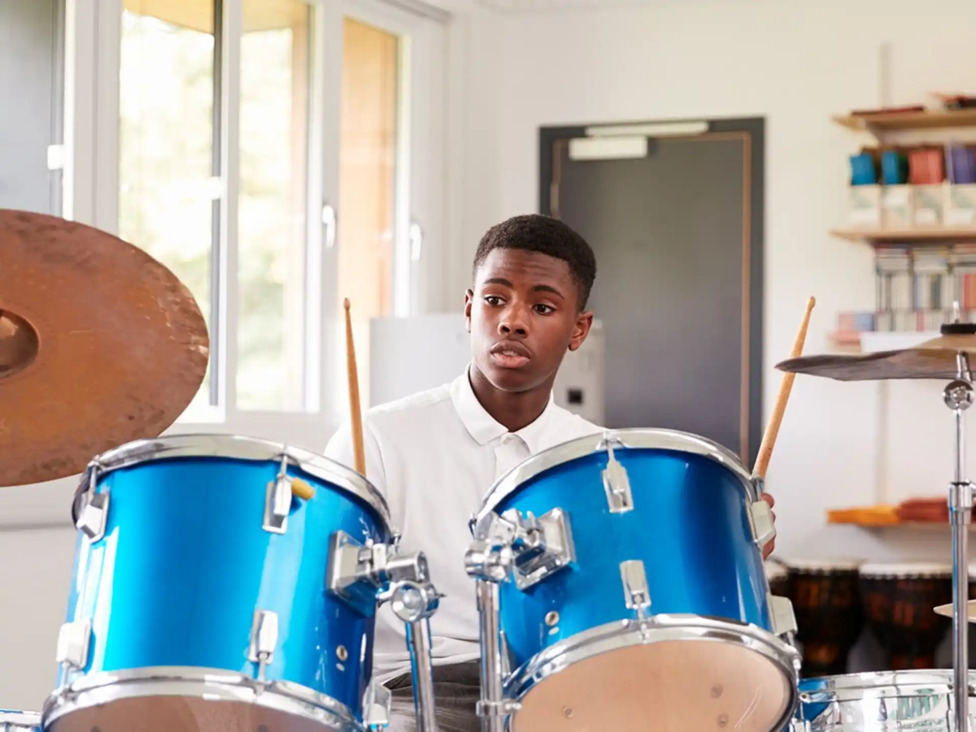 a man standing behind a drum set