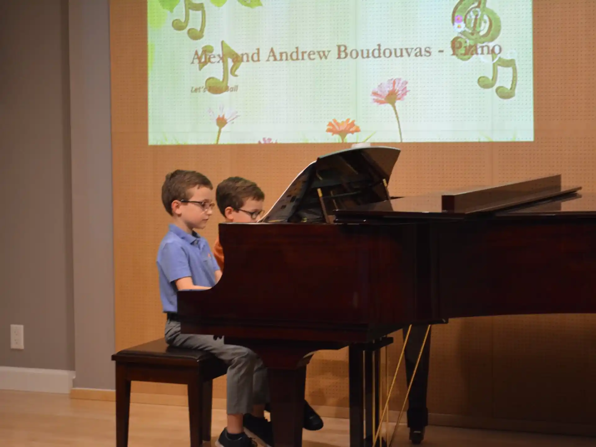 a couple of boys playing piano