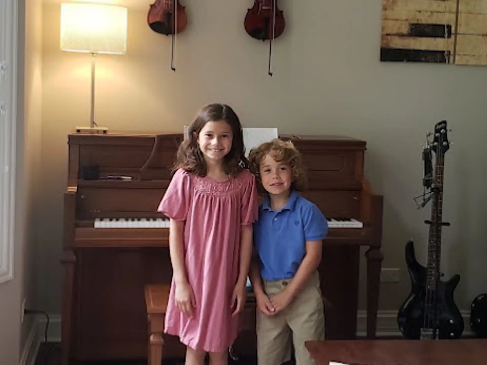 a woman and a boy posing for a picture in front of a piano