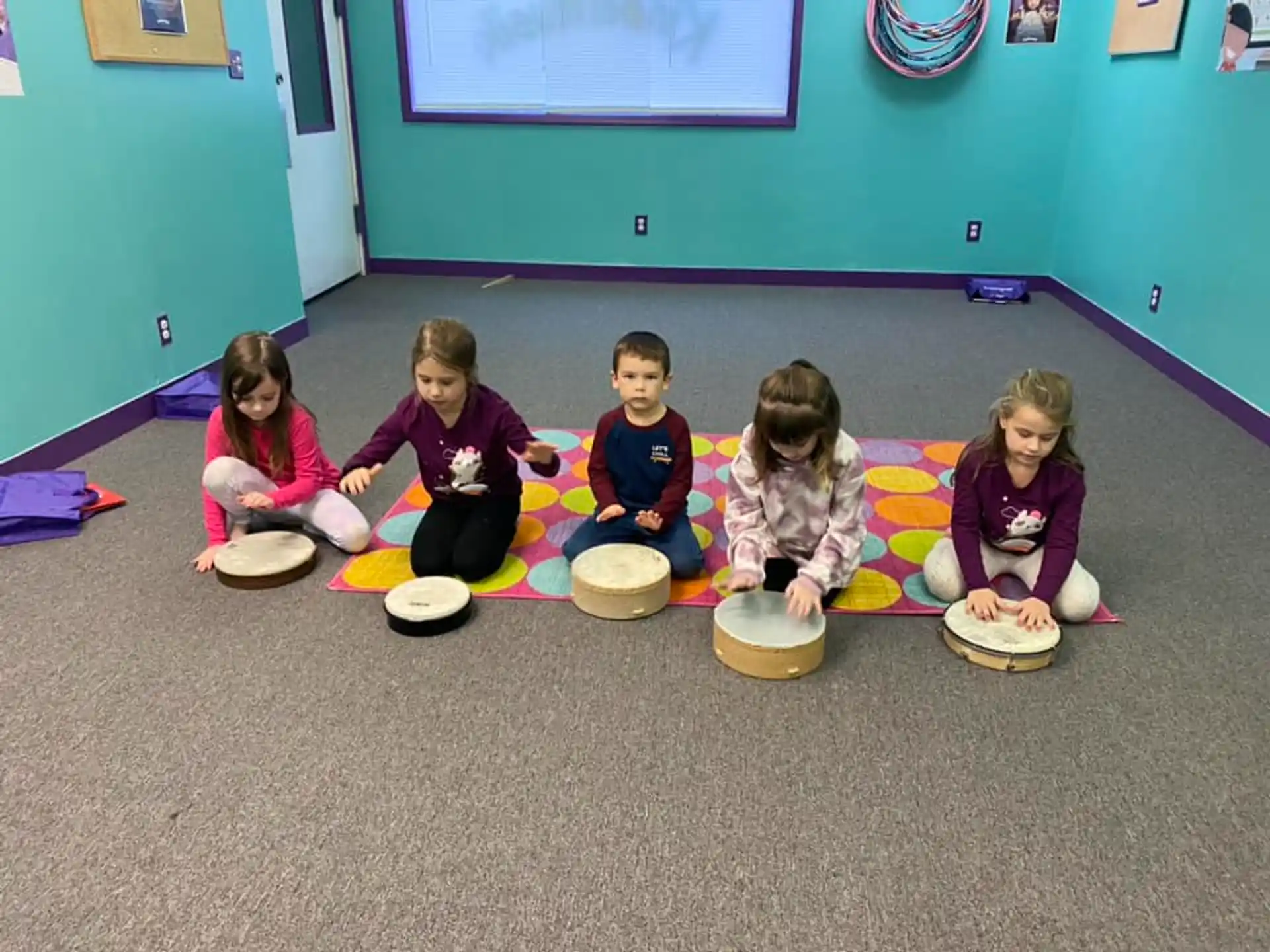 a group of children sitting on the floor with their feet on bowls