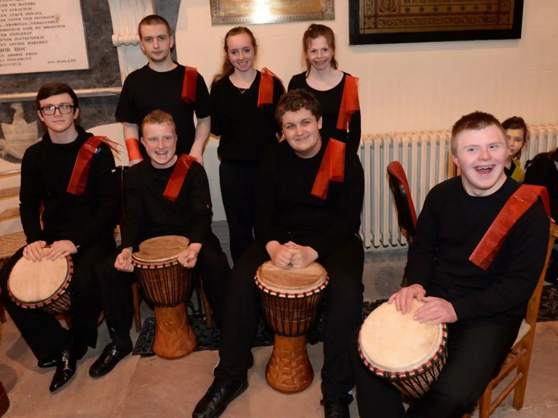 a group of people wearing uniforms and holding drums